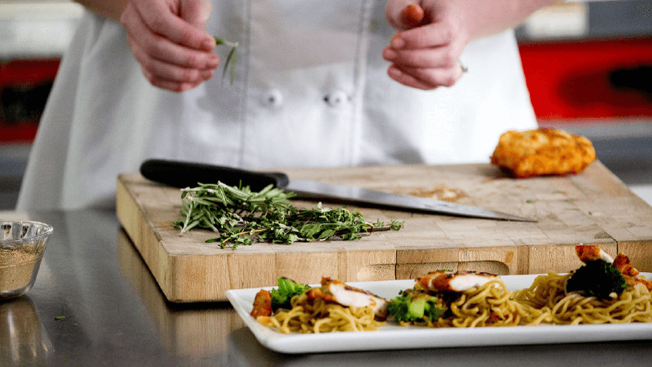 T3_CulinaryInnovation_LARGE_Carousel_2.jpg A chef is preparing food.