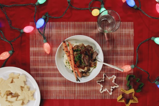 This is a photo of a plate of food with Christmas lights surrounding it.