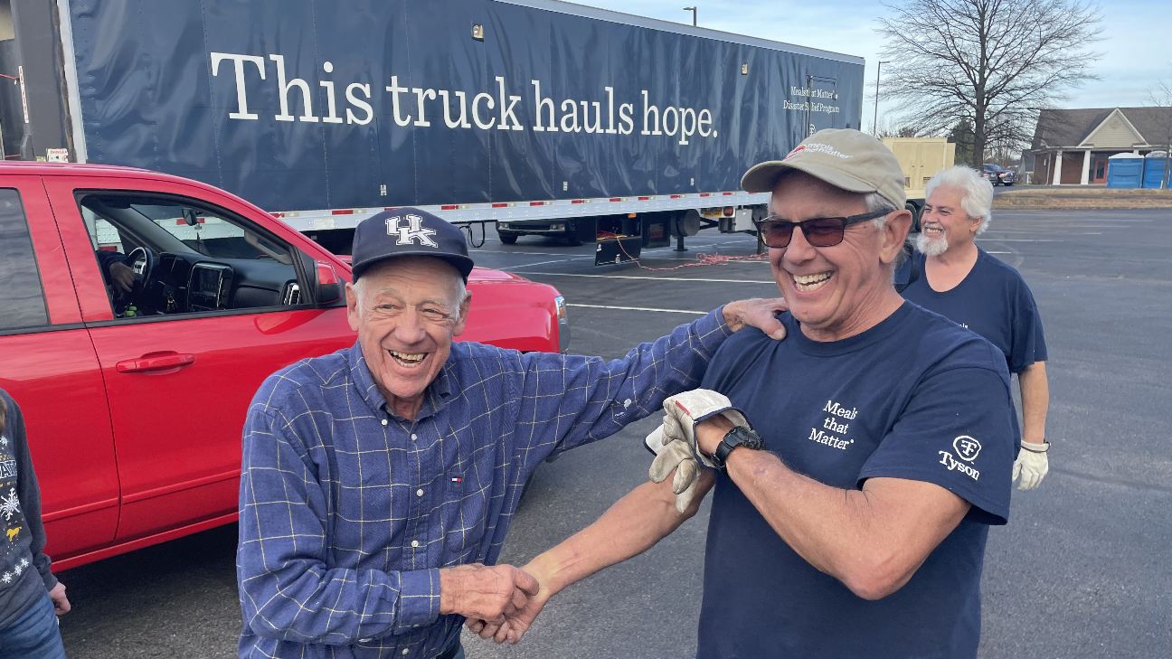 A photo of the Meals on Wheels truck and men smiling.