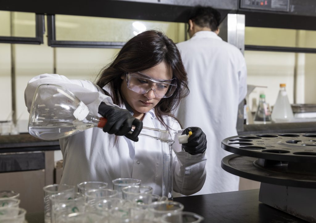 Fostering a culture that puts food safety first Woman in lab pouring liquid into a beaker