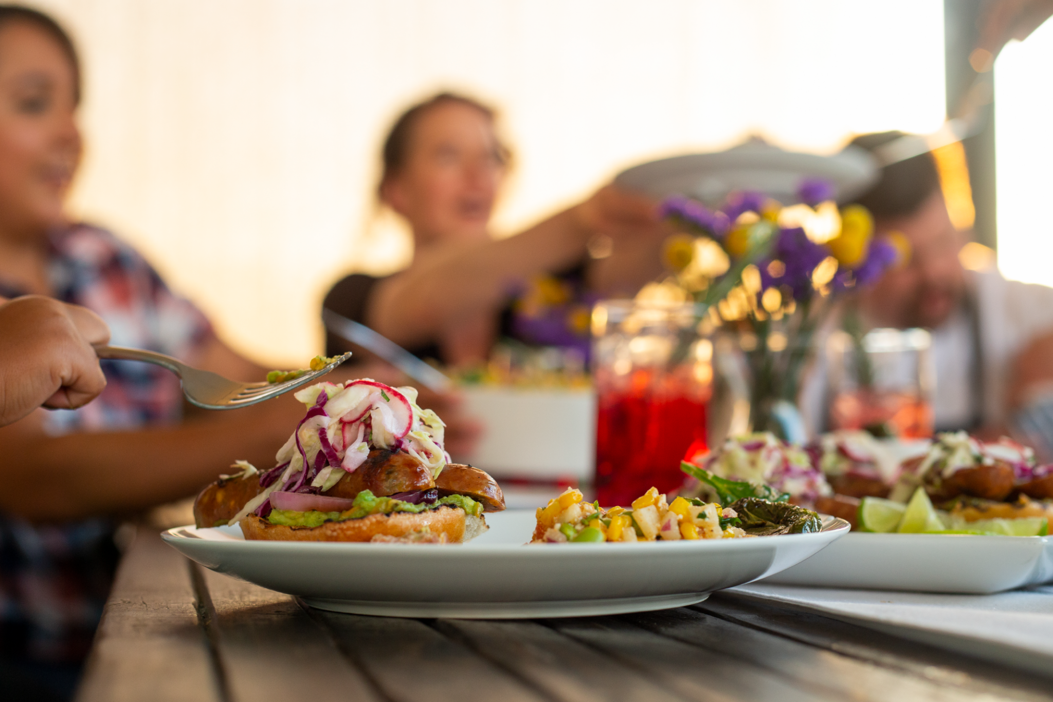 Passing a plate at a picnic table dinner