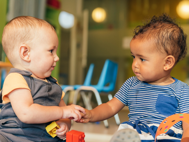 This is a photo of two babies playing together.