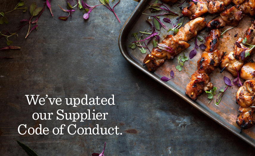 Tabletop with pan of cooked chicken and text reading: We've updated our Supplier Code of Conduct